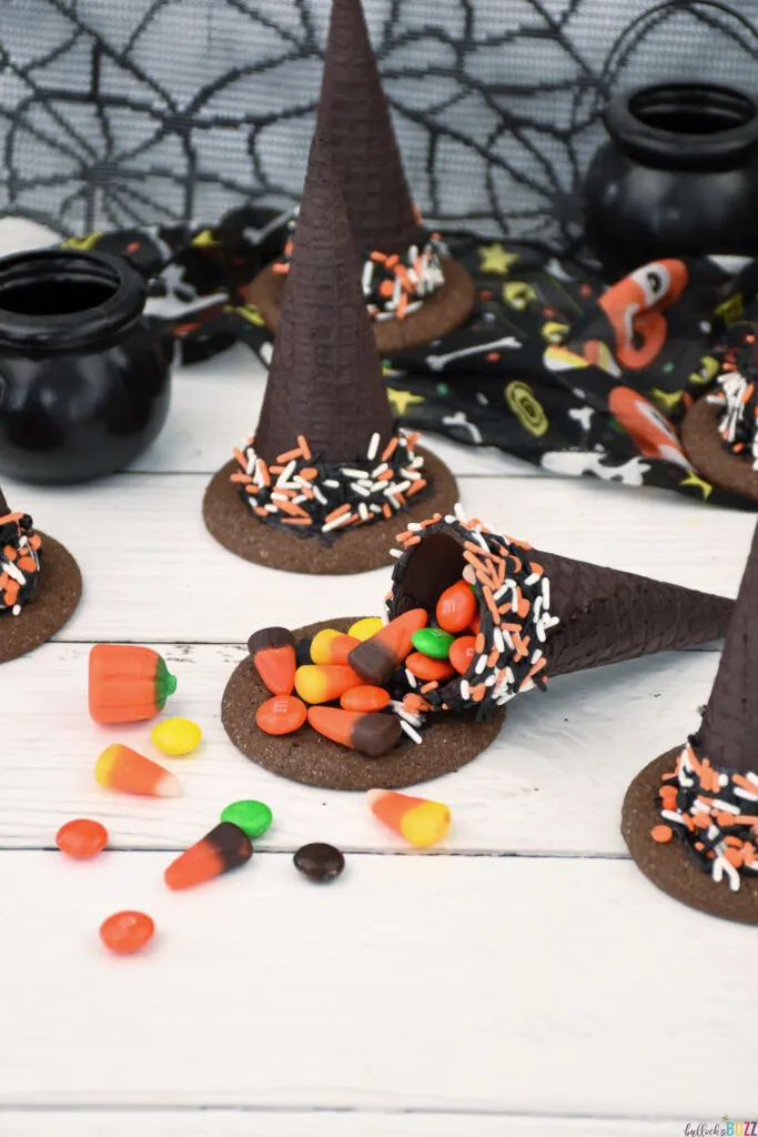 A Halloween Candy-Filled Witch Hat broken open so its candy is spilling out onto the tabletop.