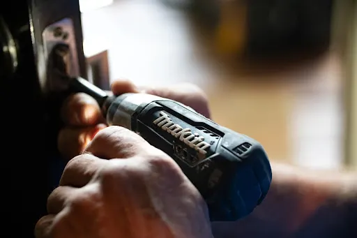 man using a drill while watching out for any home renovation mistakes