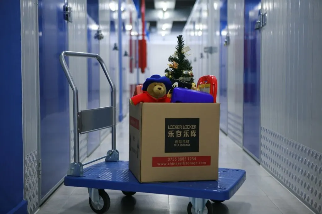 A cart with a box on it outside a storage room. Renting storage is a great way to make more space in your home