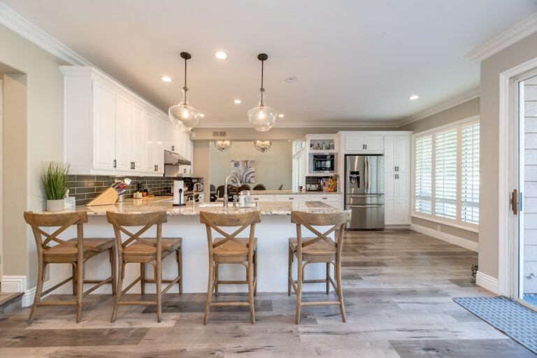 A beautifully remodeled kitchen with white cabinets and a gray backsplash. Take a look at these common signs your kitchen needs an upgrade.