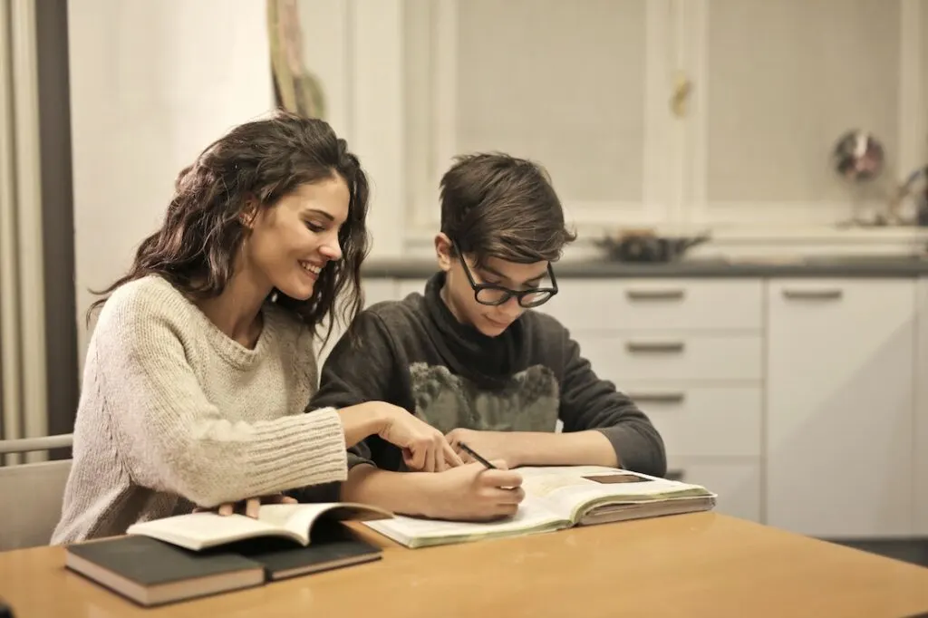 mom homeschooling son at the table as one of the ways to incorporate learning into your child's everyday life