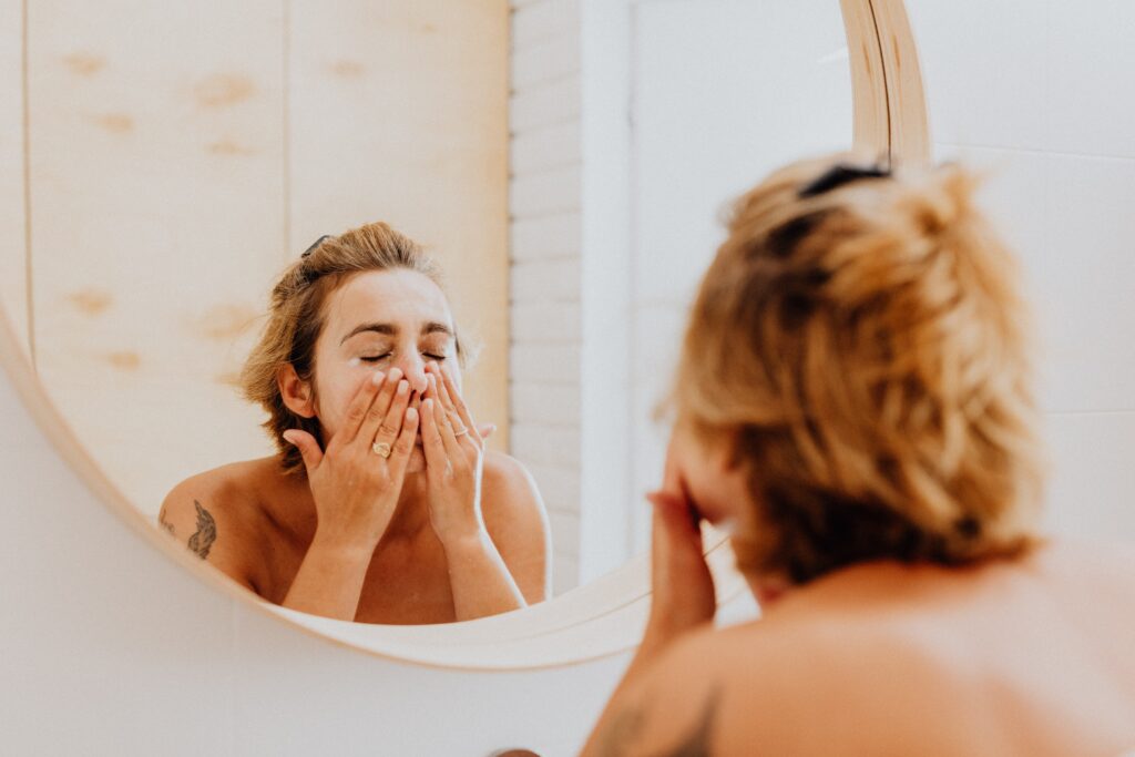 A woman washing her face with her must-have skincare products