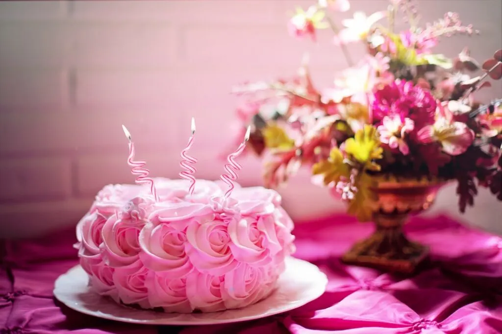 A pink cake, pink tablecloth, pink flowers and pink decor as part of one of the most popular party theme ideas - Pink Party.