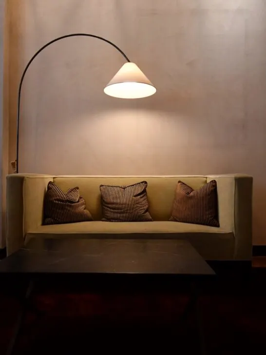 A couch illuminated by a floor lamp illustrates how furniture adds style - another key role of new furniture in home renovation.
