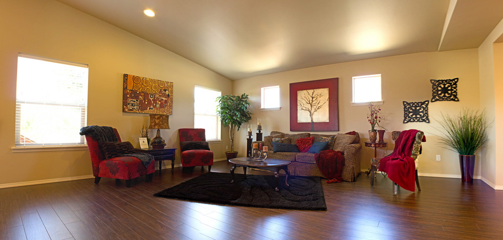 A living room with cream walls and in-ceiling lighting, and lots of windows. Create a room like this by enhancing the ceilings of your home.