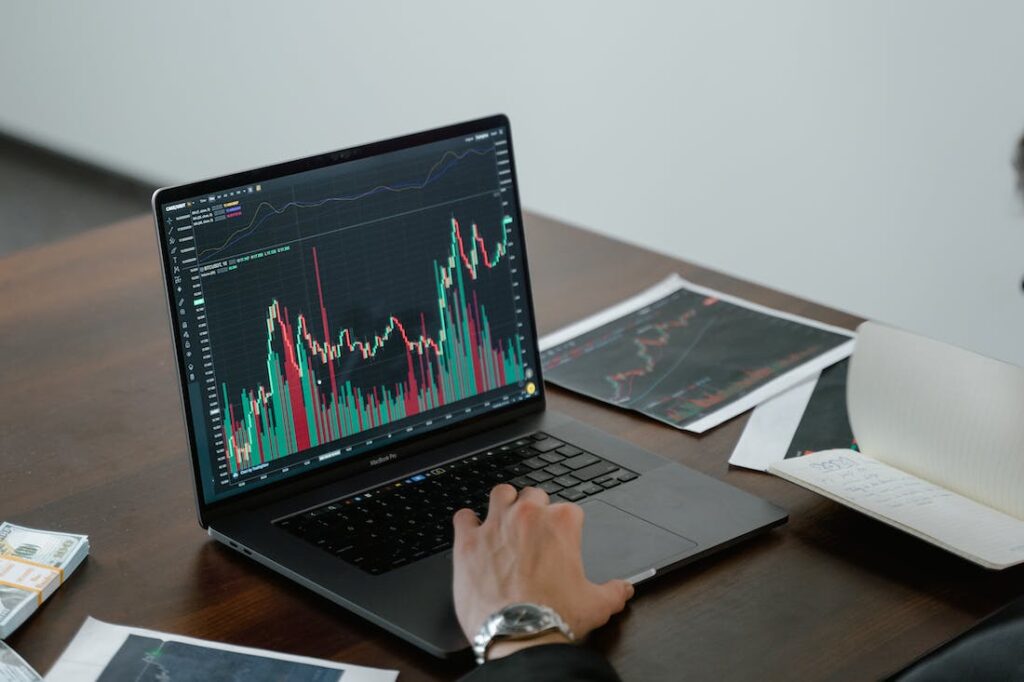 man working on laptop showing online investing and trading charts