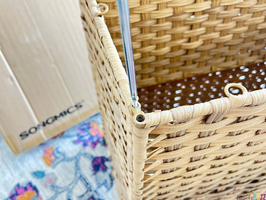 Using a screwdriver to connect the sides of the laundry hamper