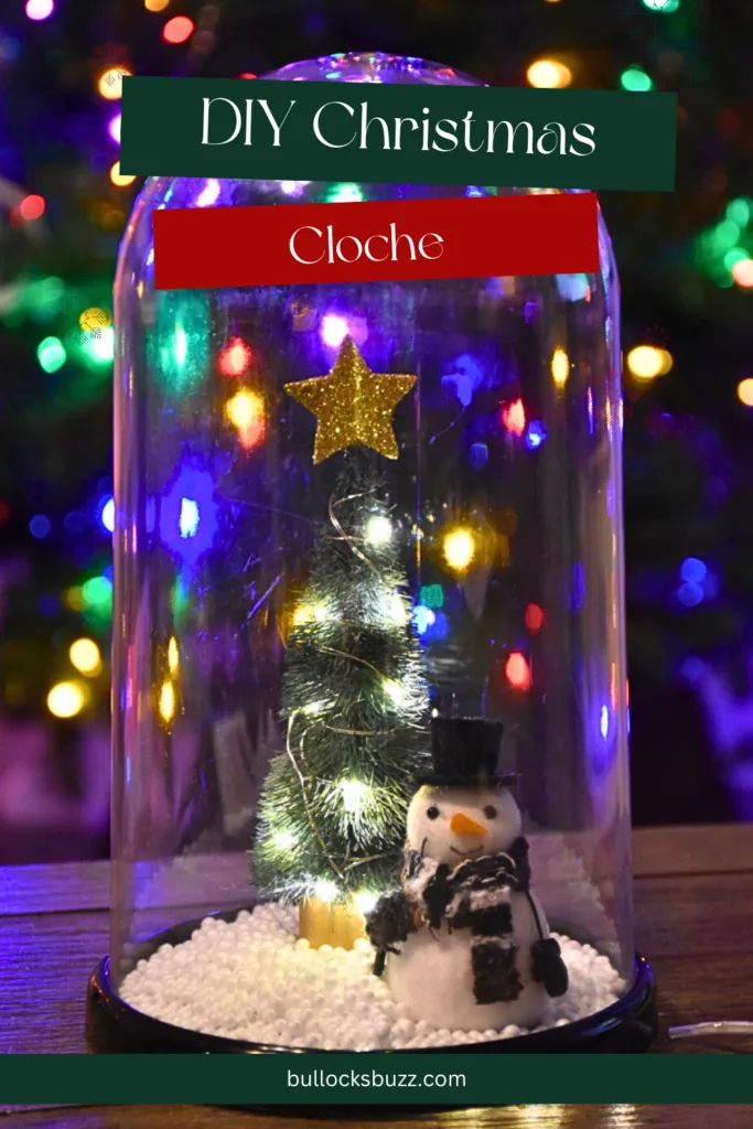 The completed Christmas Cloche, elegantly displayed on a table, illuminated by the warm glow of a festive Christmas tree in the background.