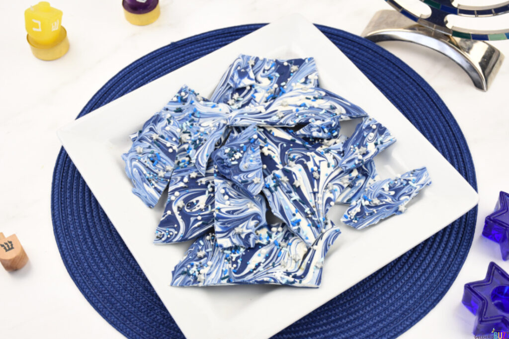 Blue and white Hanukkah Bark on a plate sitting on a blue placemat