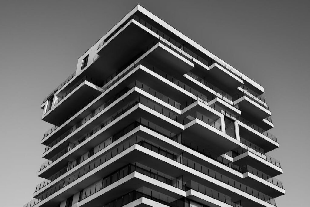 Black and white photo of a high rise building with lots of sharp angles and other interesting designs