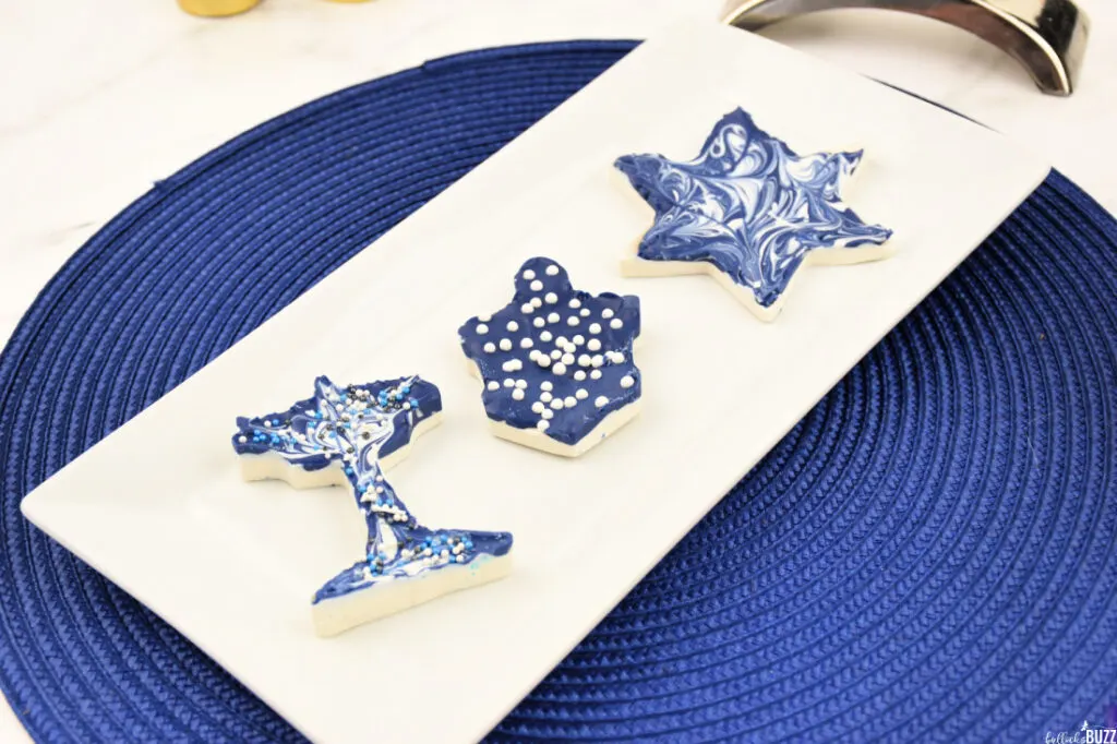 Overhead angle of three pieces of homemade candy for Hanukkah sitting on a white plate