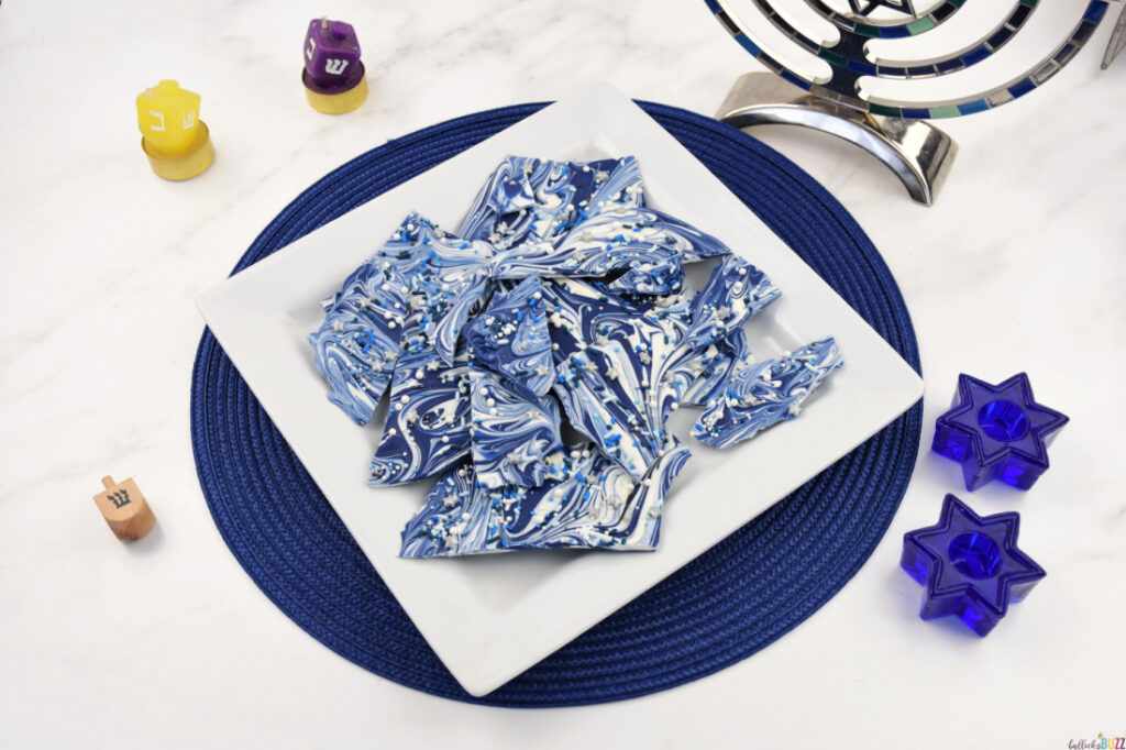 Hanukkah Bark Candy broken apart and placed on a white plate