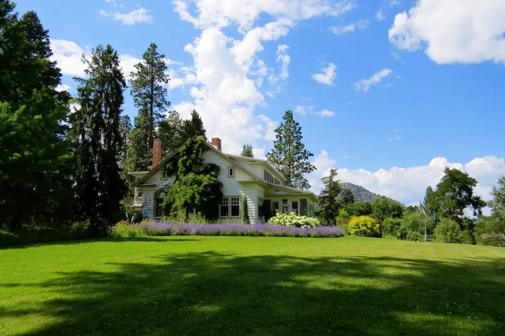 Beautiful lawn surrounding a white house comes from knowing how to grow and maintain a healthy lawn