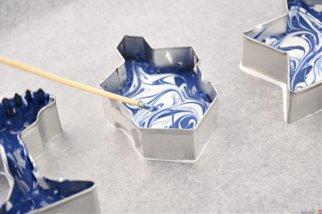Use the tip of a skewer to swirl blue and white chocolates