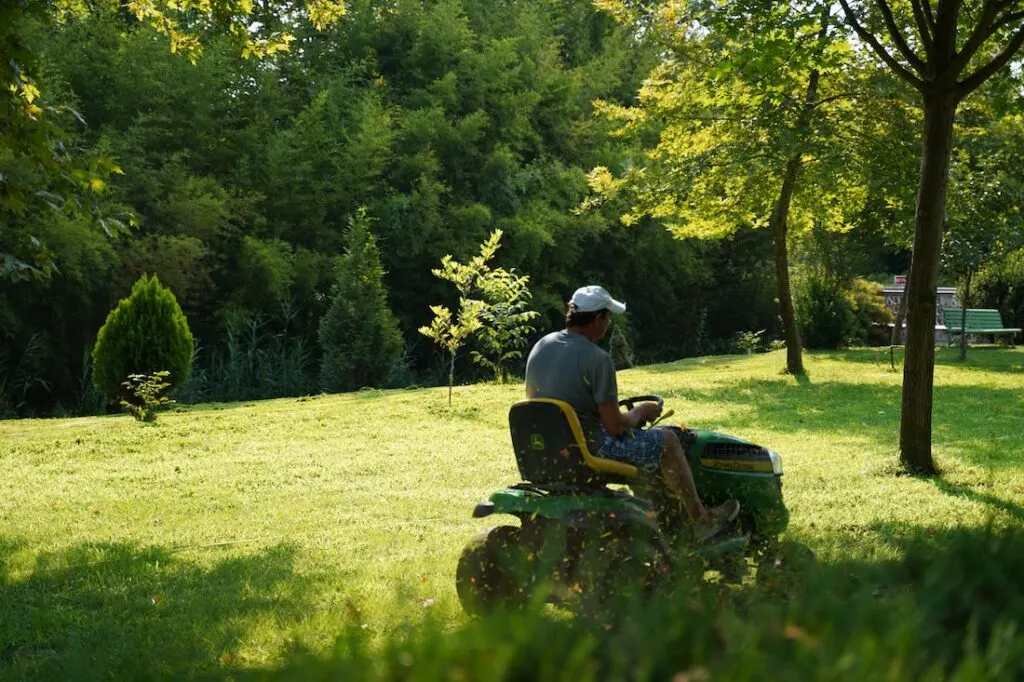 man mowing his lawn using a riding lawn mower
