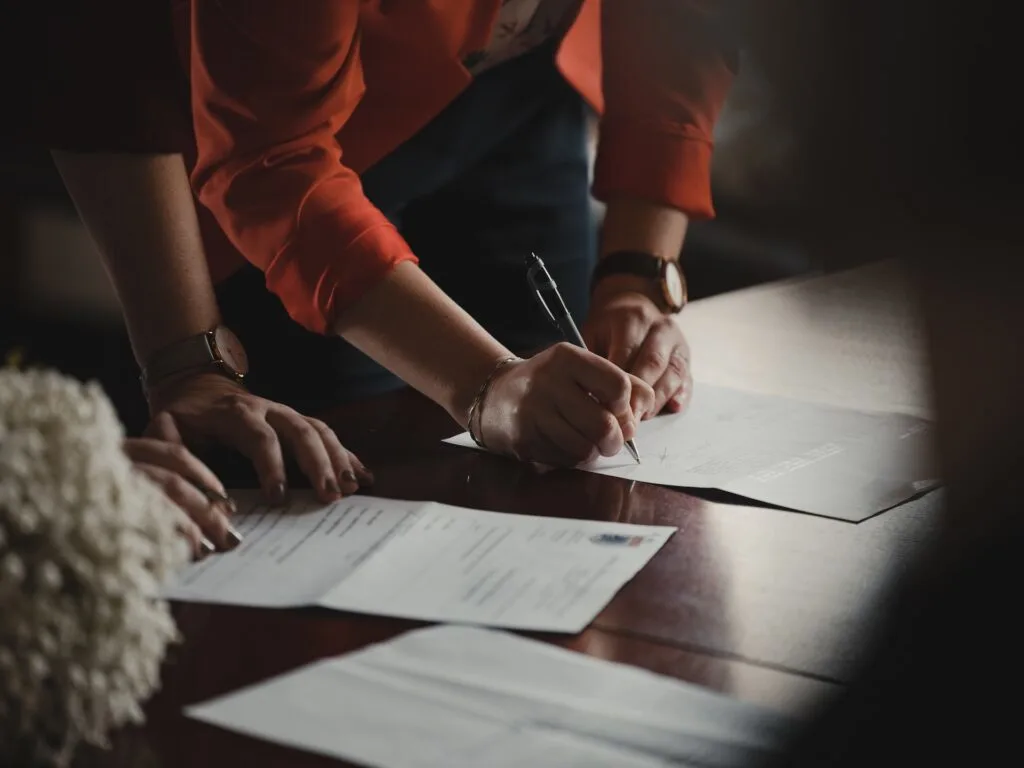 a woman in orange working at a table while navigating a criminal case