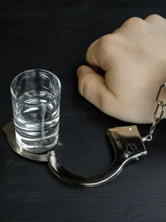 A man's write handcuffed to a shot glass showing how hard being able to stop substance abuse truly is despite these sobriety tips