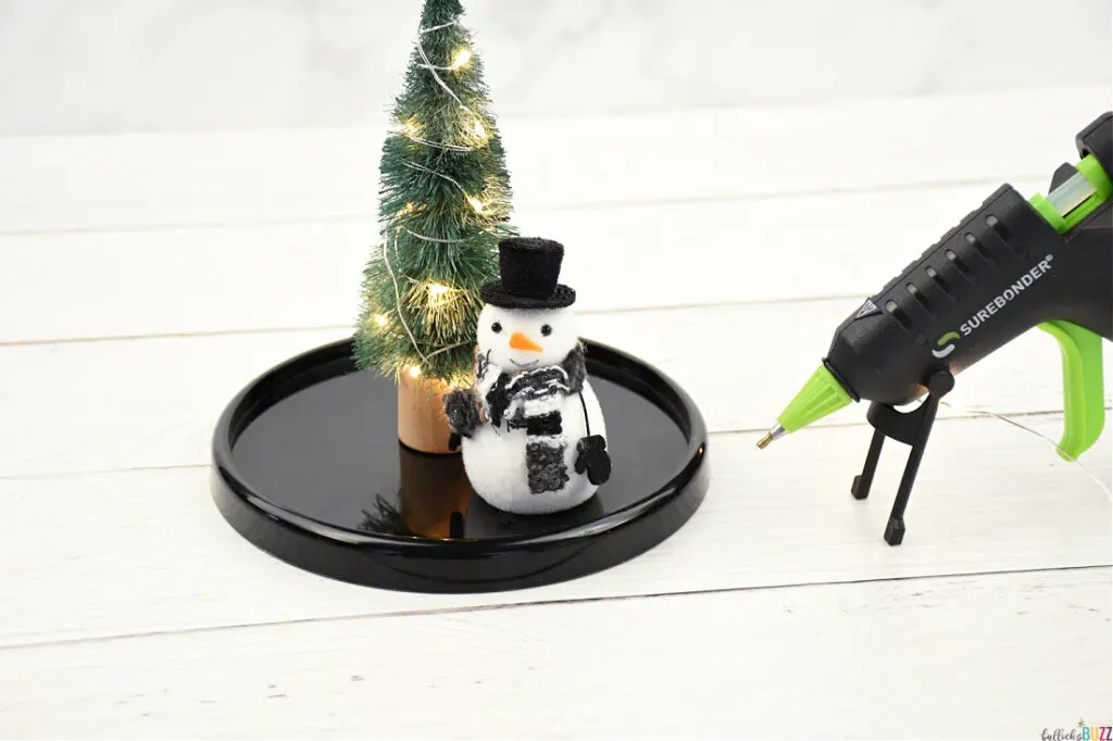 Miniature Christmas tree and snowman secured in place with hot glue for DIY Christmas Cloche 