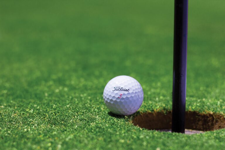 A golf ball on the edge pf a hole during first golf game