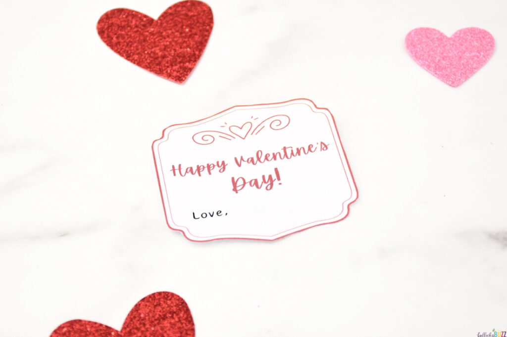 A 14 Days of Valentines gift tag on a white background, surrounded by scattered red and pink hearts.