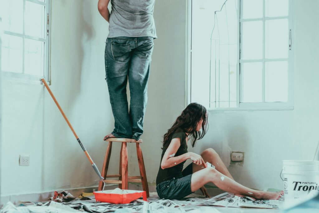 Man and woman working painting a room. This is one way to upgrade your home.