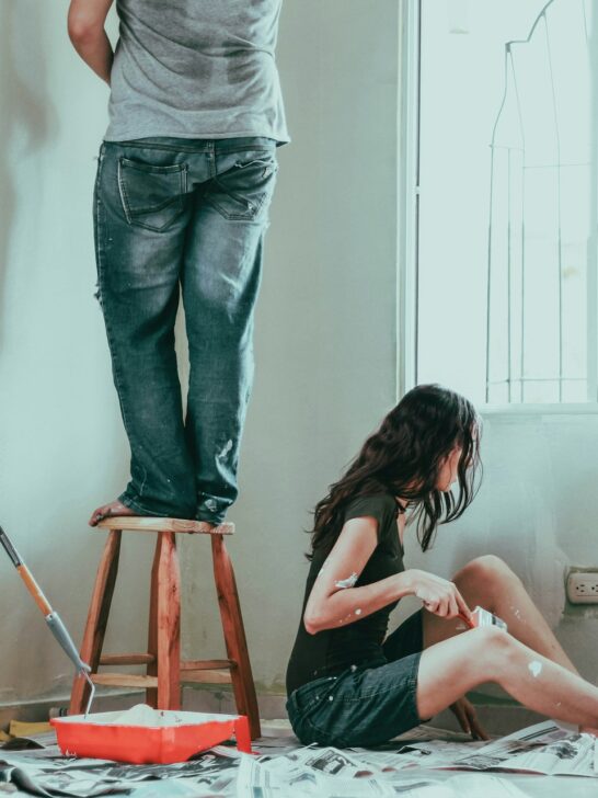 Man and woman working painting a room. This is one way to upgrade your home.
