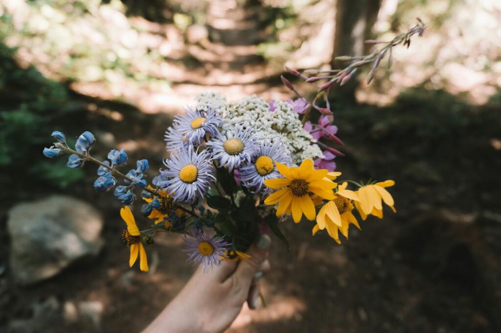 A person holding a bouquet of wildflowers