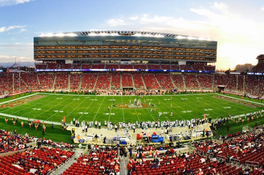 An NFL stadium packed with fans and the players on the field