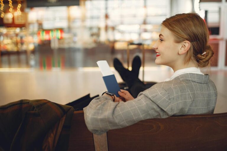 Smiling woman waiting in airport on her plane excited about funding your dream vacatio