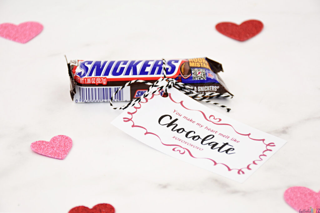 A Snickers candy bar paired with a tag that reads 'You Make My Heart Melt Like Chocolate' for a 14 Days of Valentines gift.
