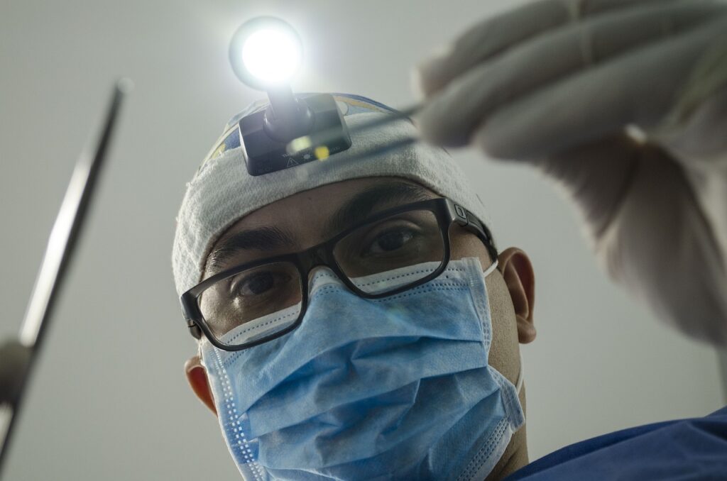 Looking up at a dentist with light on his head