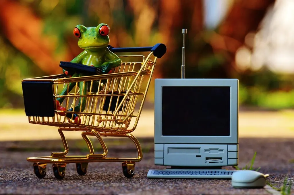 Небольшой компьютер и корзина для покупок, чтобы представить покупки в Интернете как одну из многих осознанных покупок.