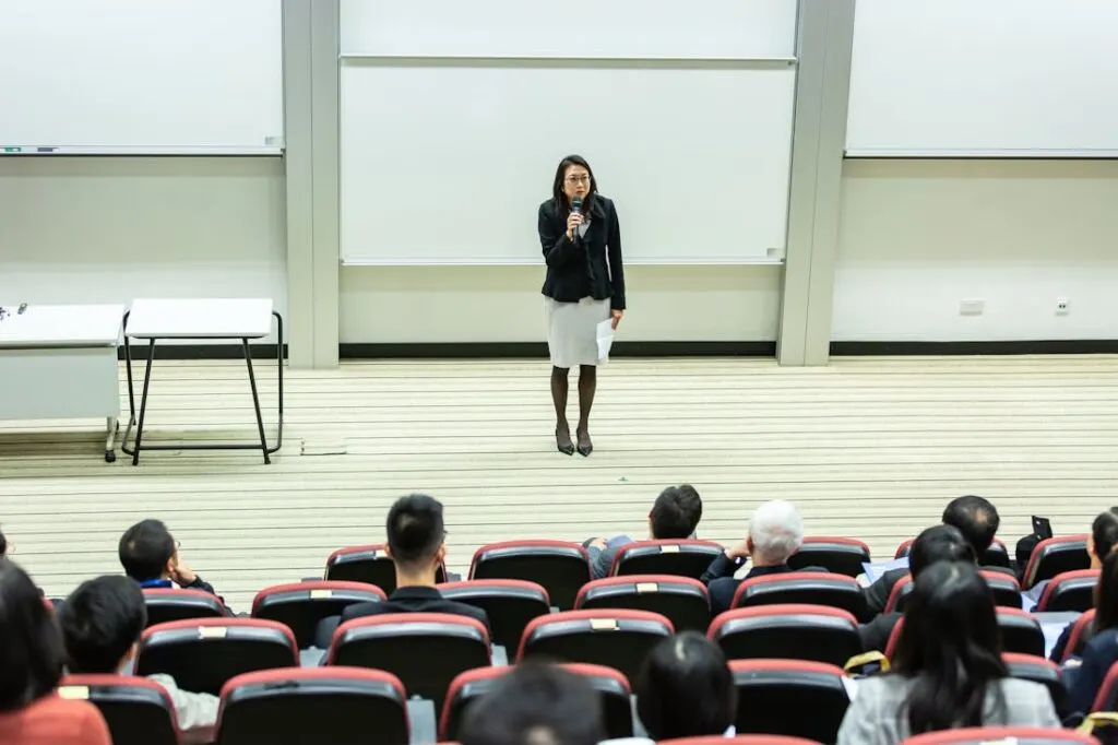 Professor facing her class and teaching in an auditorium