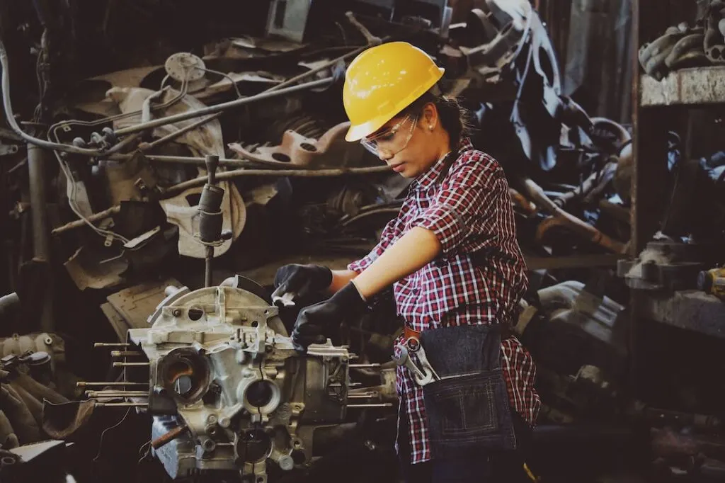 A woman working on an engine as part of proper caravan maintenance