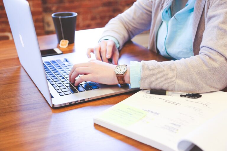 Person working on their laptop and using time management skills.