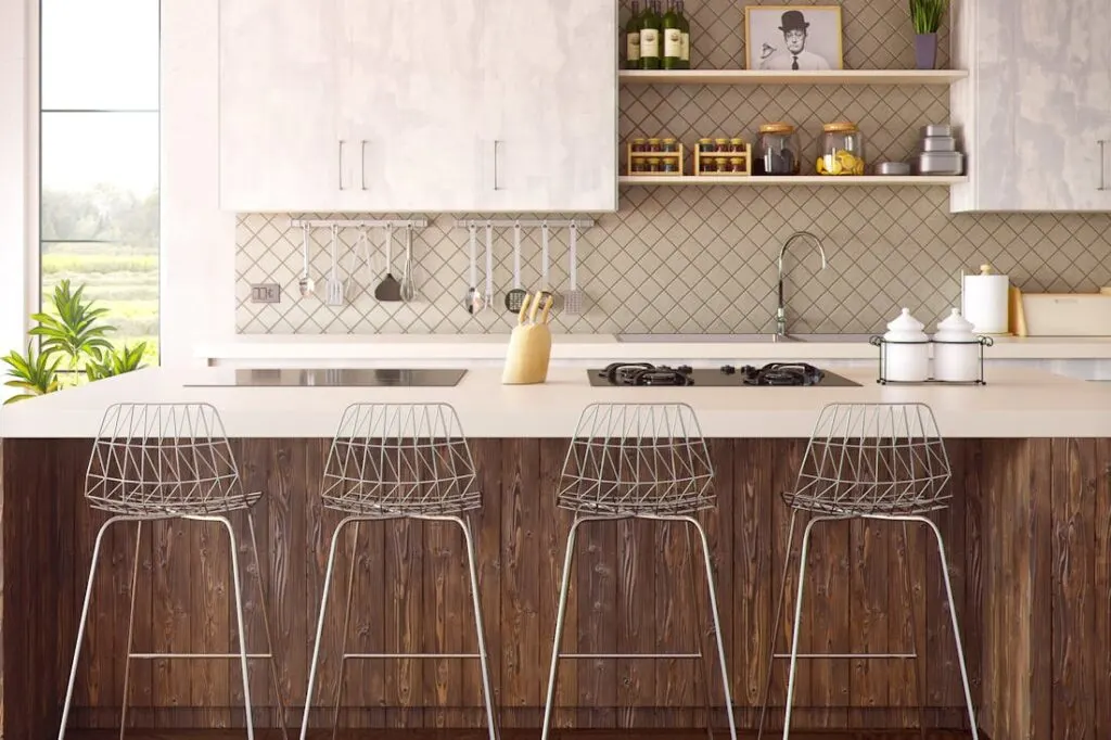 Bar stools in front of a breakfast bar in a modern kitchen. 