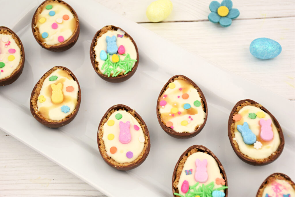 Close-up of Cheesecake Filled Easter Eggs on a white tray, highlighting the detailed decorations and rich cheesecake filling.