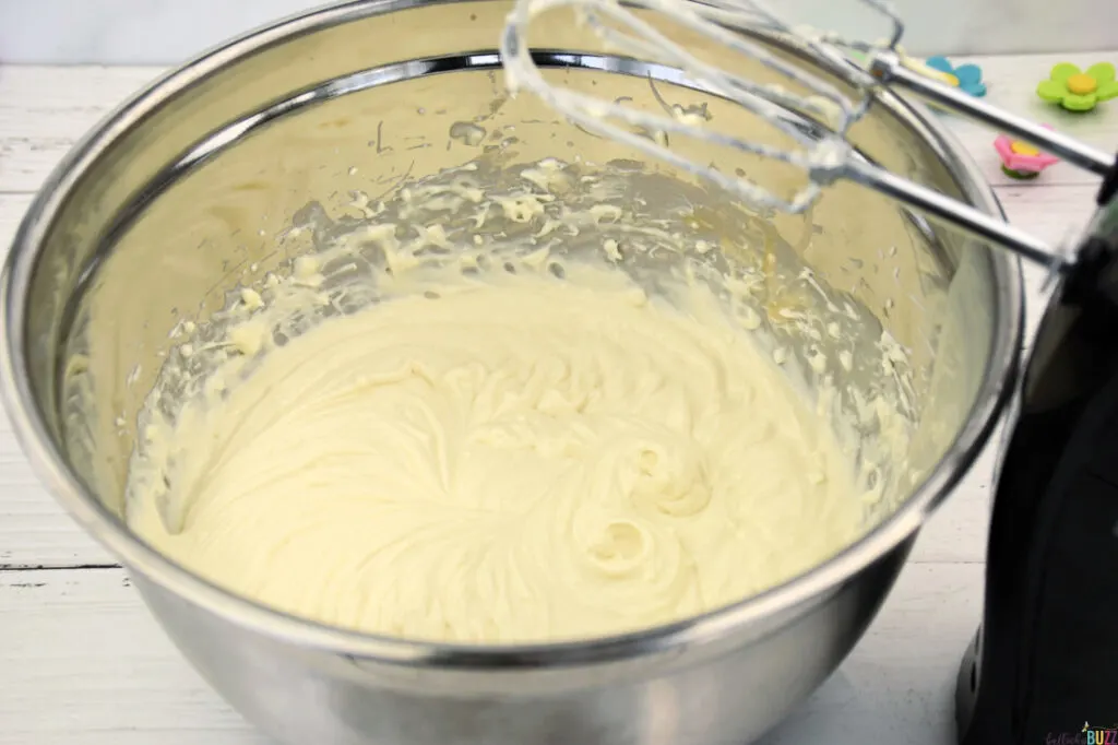 Smooth and creamy cheesecake filling in a stainless steel bowl after mixing.