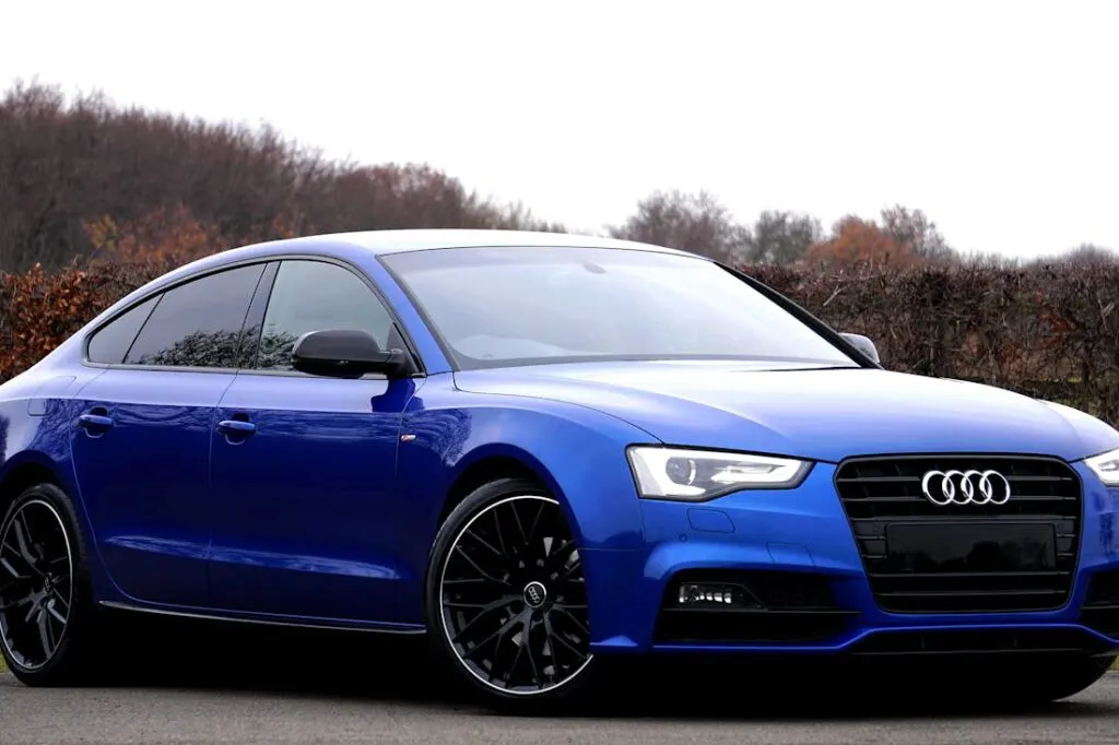 A side view of a brand new blue Audi sports coup.