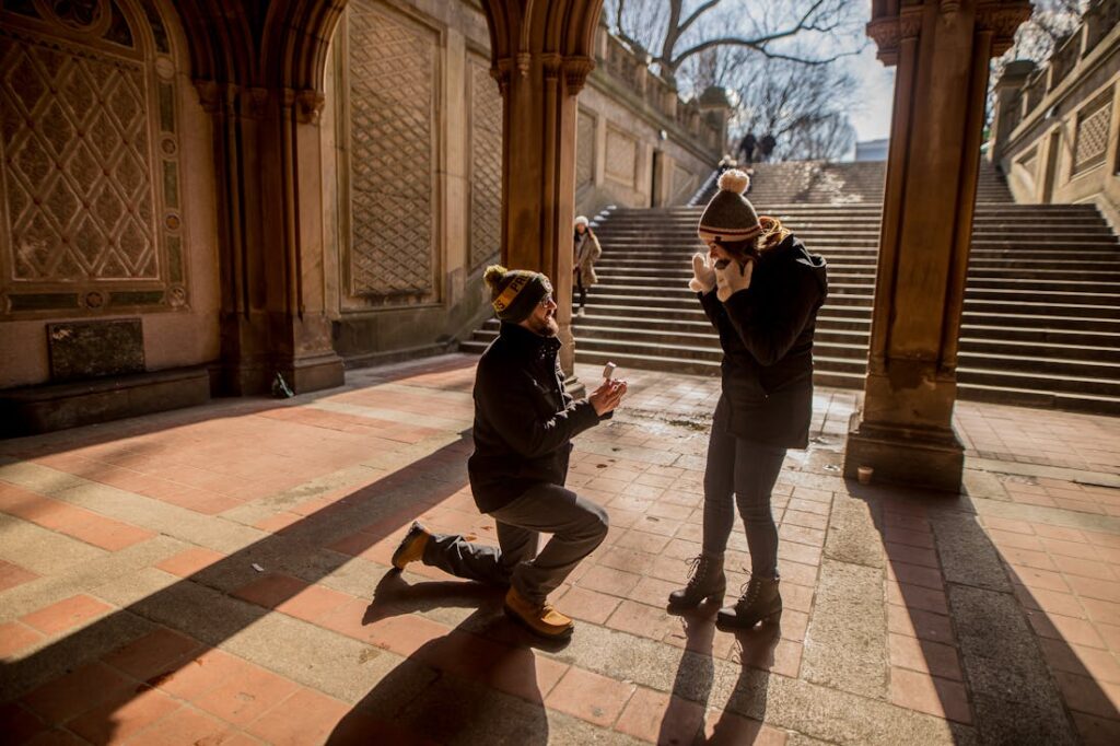 A man on his knees proposing marriage  in a romantic spot after crafting the perfect proposal. 