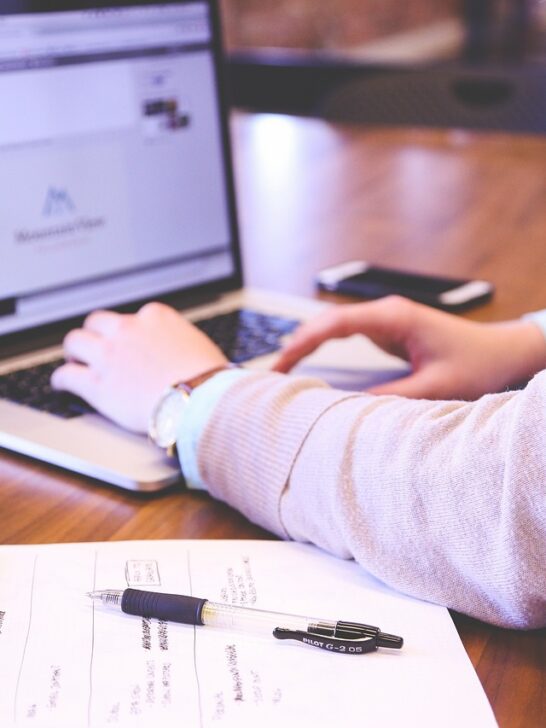 A woman working on her laptop using effective marketing strategies to help her business succeed.