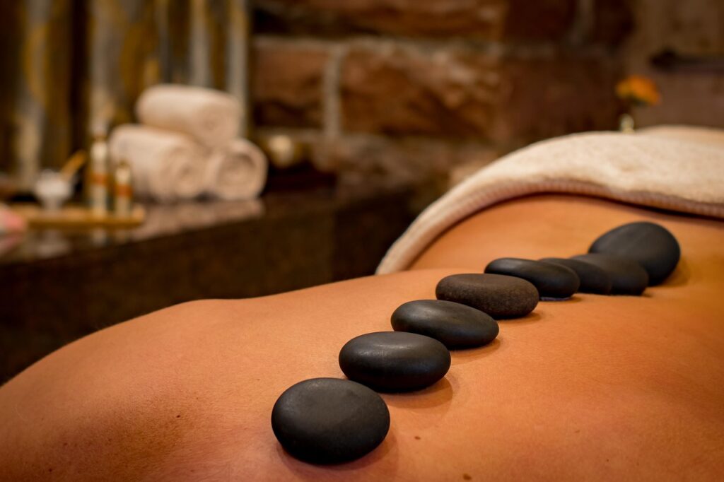 A woman laying on her stomach having a hot rock massage after finding the perfect medical spa for her needs.