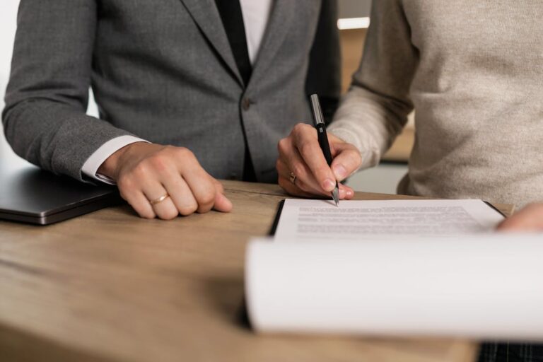 Man signing papers as part of dealing with insurance issues.