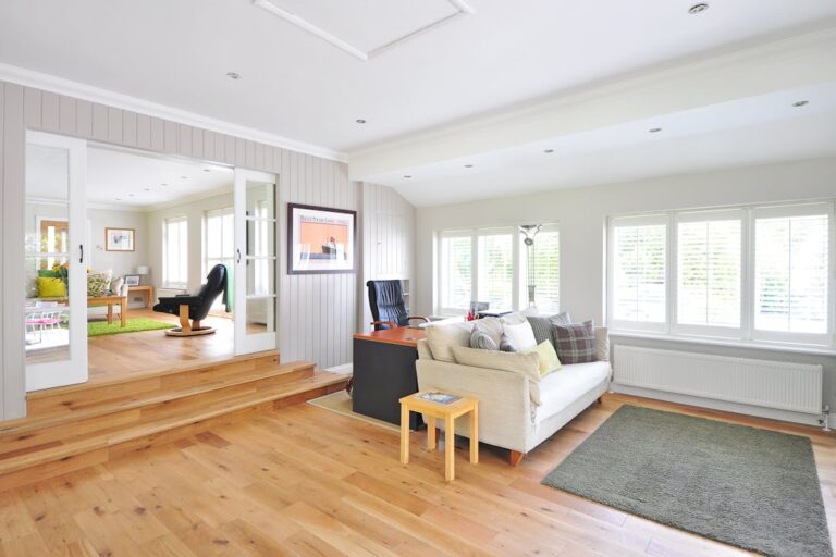 Functionality is an important consideration when selecting the right flooring for your home like these gorgeous oak floors in both rooms of this open concept house with white walls.