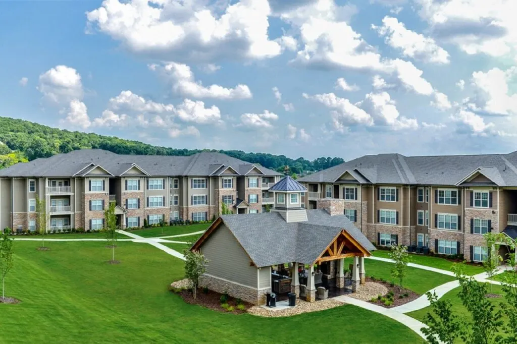 A group of apartments on a green hillside. Take a look at the key factors that influence rent prices from economic conditions and location to social trends and government policies.