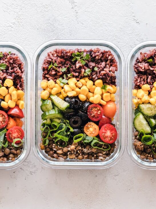 Three storage containers full of meal prepped recipes for muscle gain