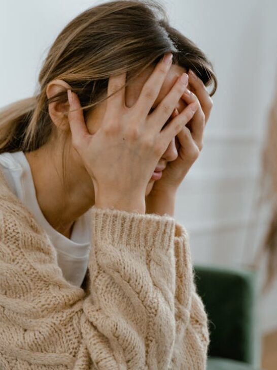 An upset woman holding her head in her hands. Using these relapse prevention tips can help you stay sober.