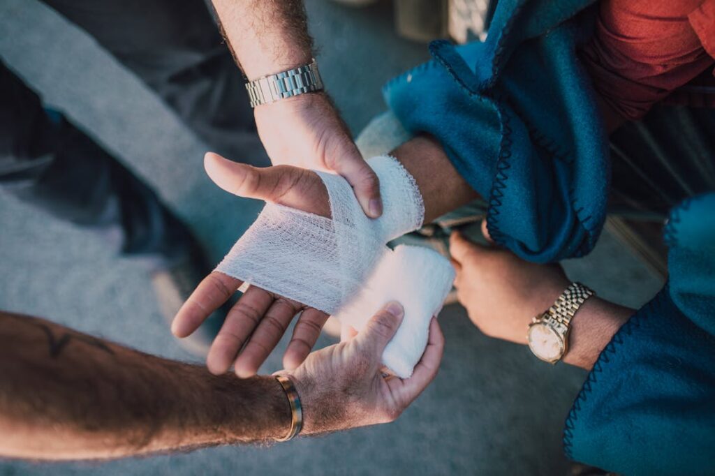 Man wrapping a person's hand after getting burned, one of the most common causes of personal injury 