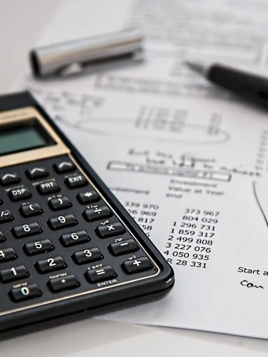 A calculator, pen, and paper working on taxes