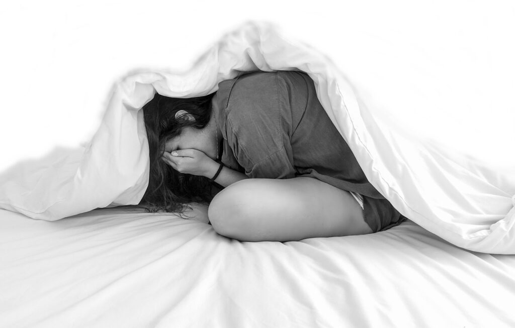A girl crying under her sheets. Therapy for adolescents can help teens navigate these crazy years.